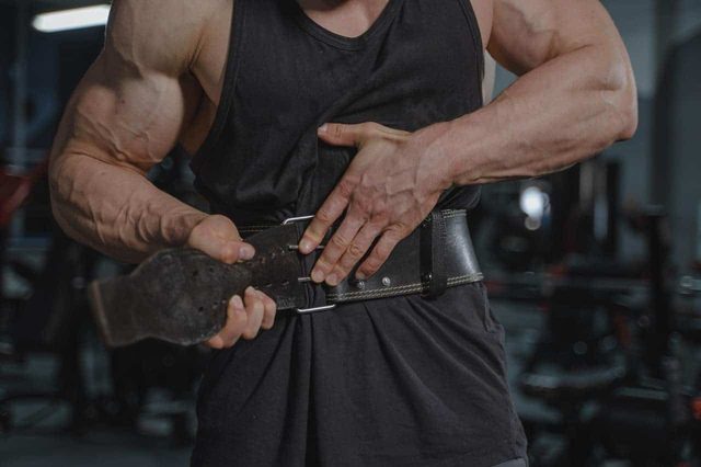 Member fastening a leather lifting belt at Muscle Up Devonport