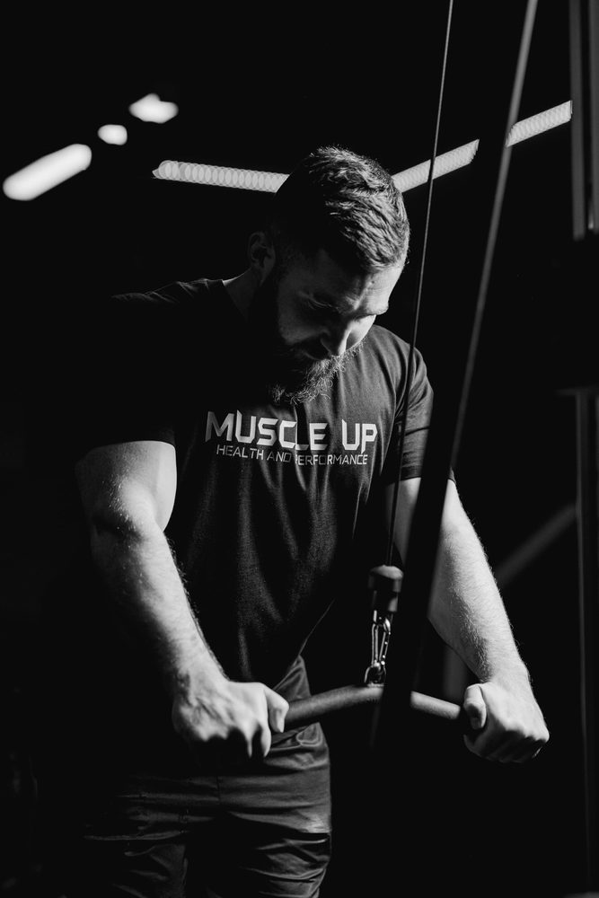 A member performing a cable triceps push down